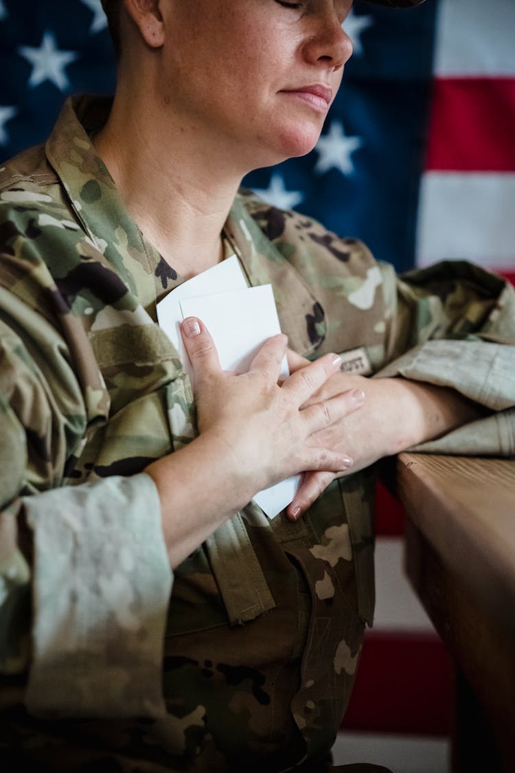 Woman In A Military Uniform Hugging Pictures Of Her Family 