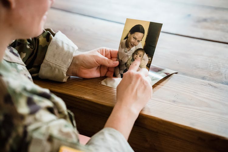 Soldier Looking At A Photo Of His Wife And Child 