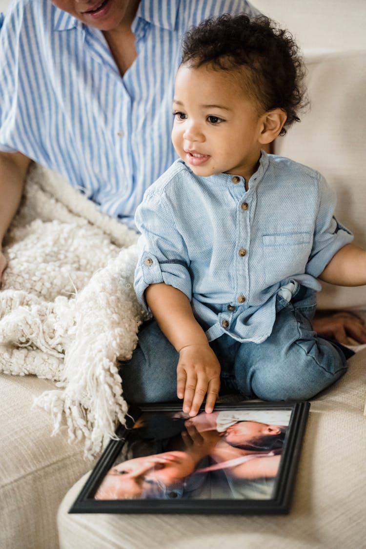 A Cute Child Holding A Picture Frame