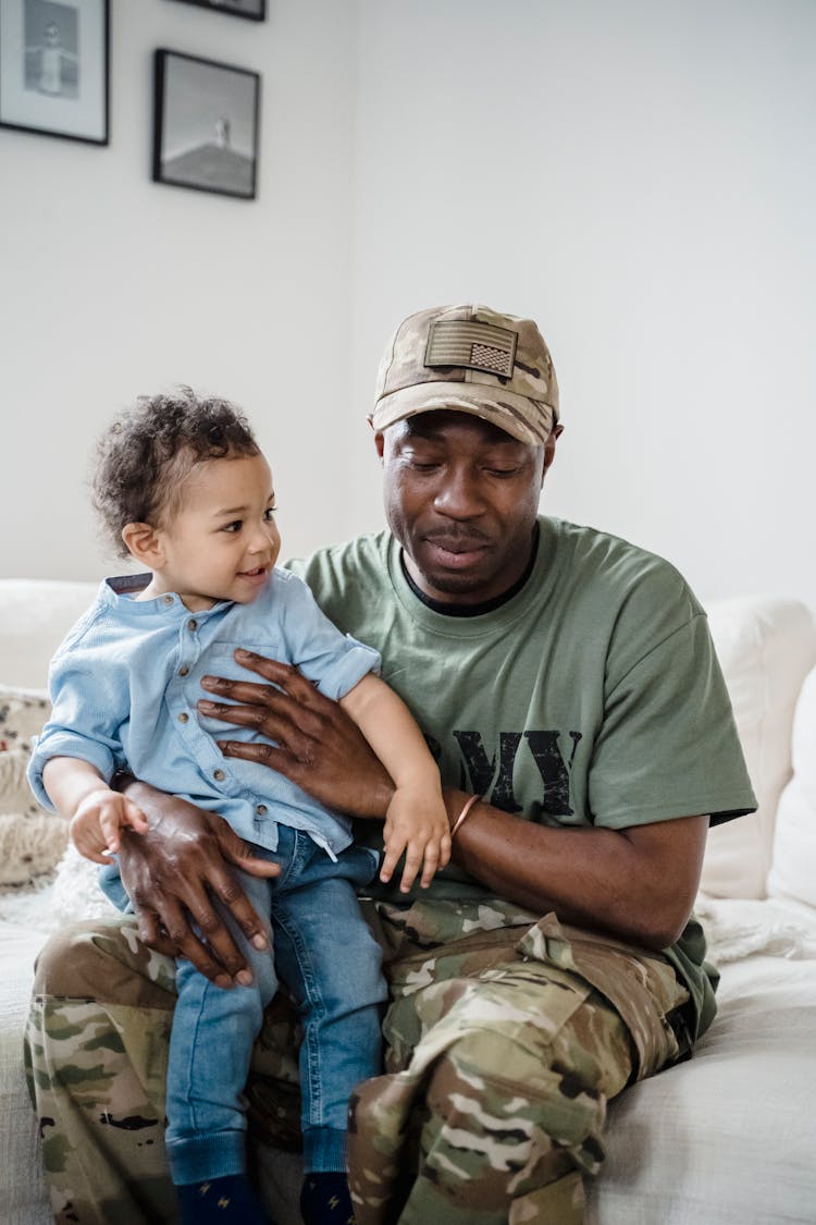 A Child Sitting On The Father's Lap