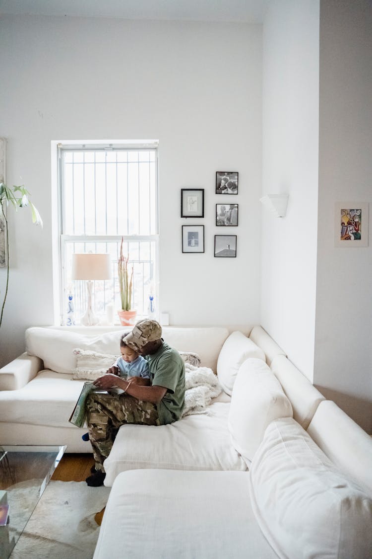 A Father And Child Sitting On The Sofa