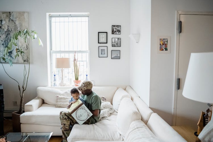 A Father And Child Sitting On The Sofa