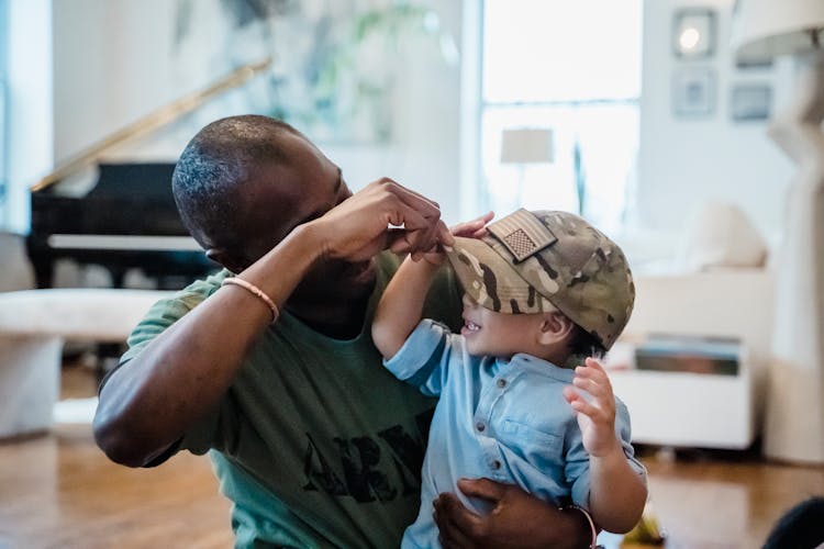 A Boy Wearing His Father's Cap