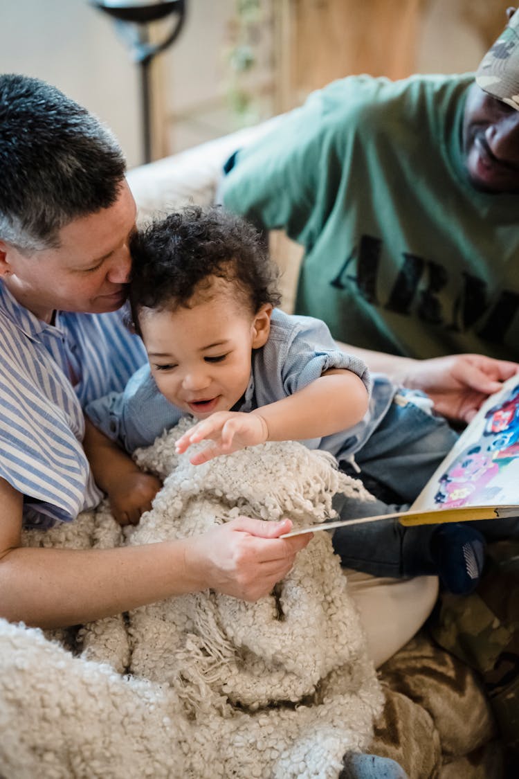 Boy Playing And Reading With His Parents