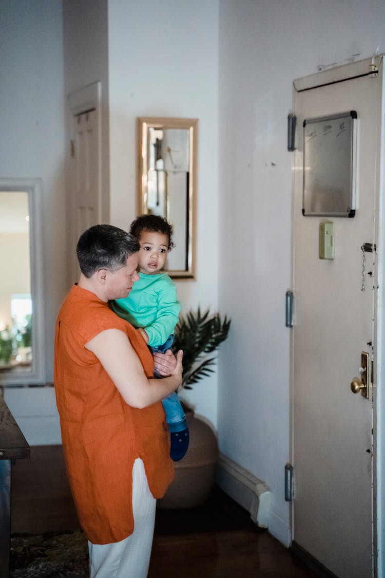 Woman Holding Her Son By A Door