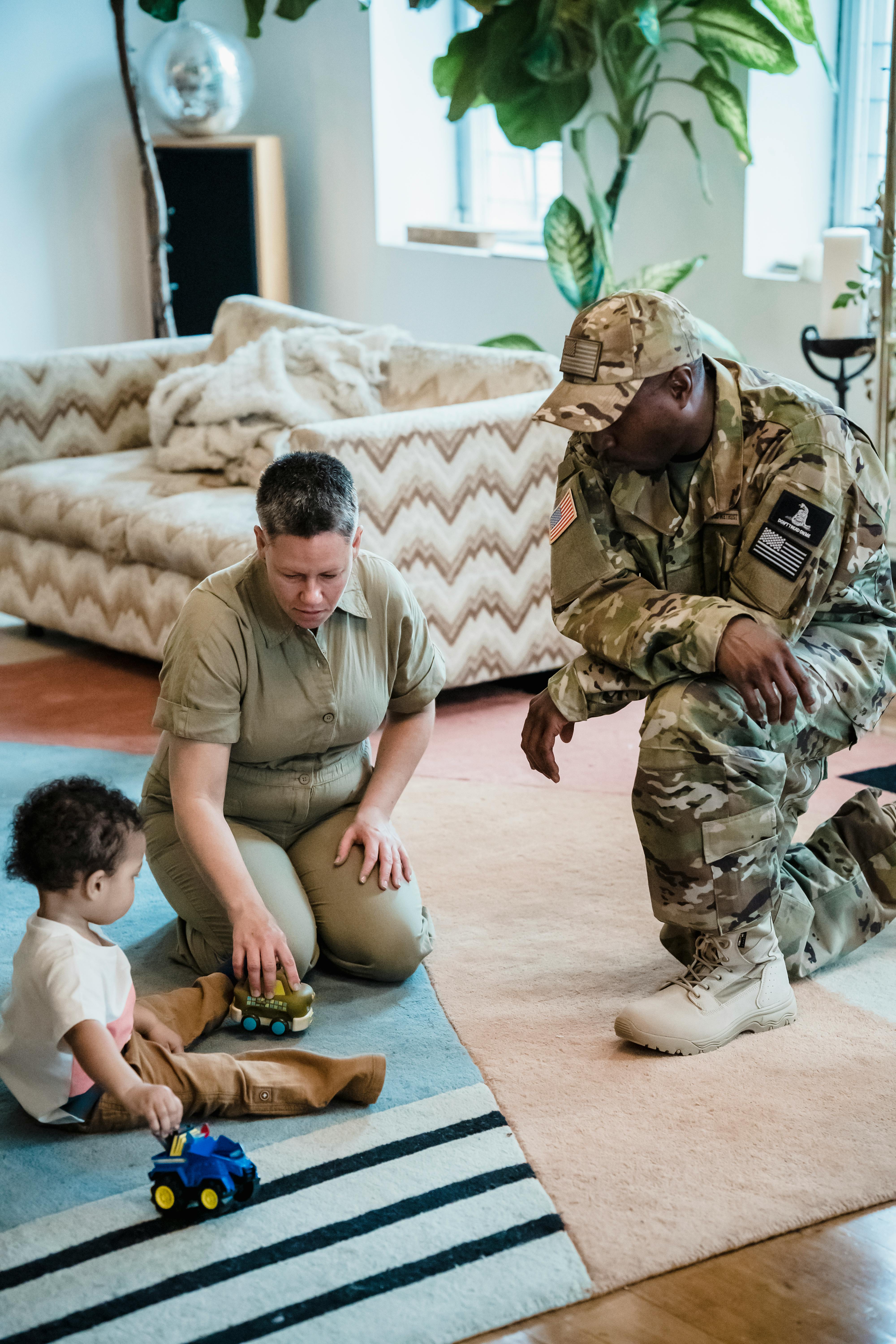 military couple playing with their son on the floor in their living room