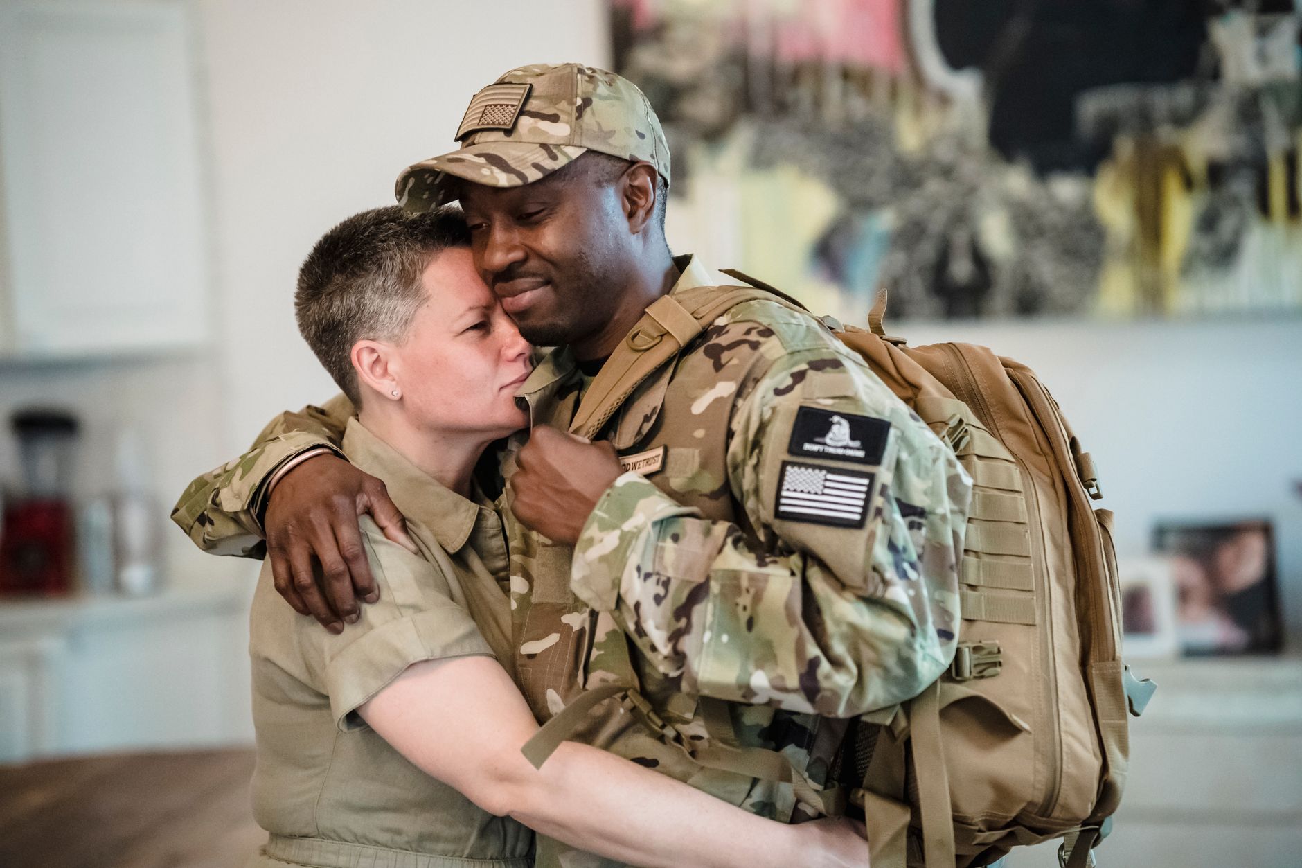 An emotional farewell embrace between soldiers indoors, showing love and support.