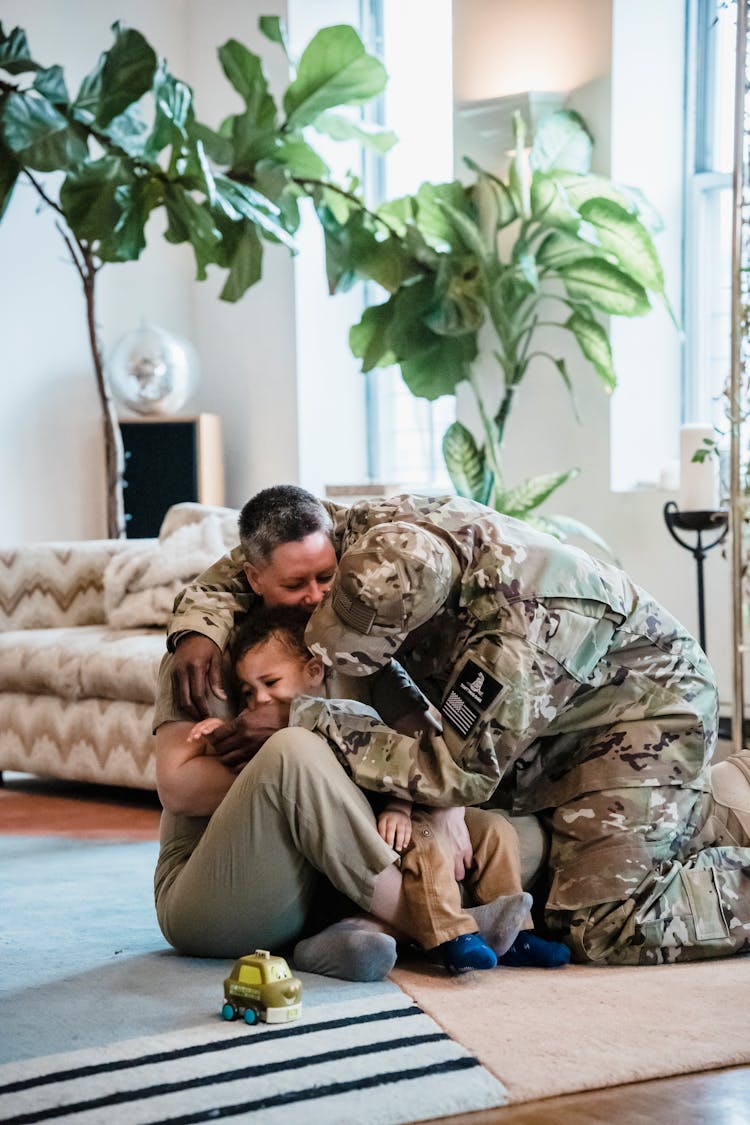 Man In Military Uniform Giving A Goodbye Hug To Woman And Boy