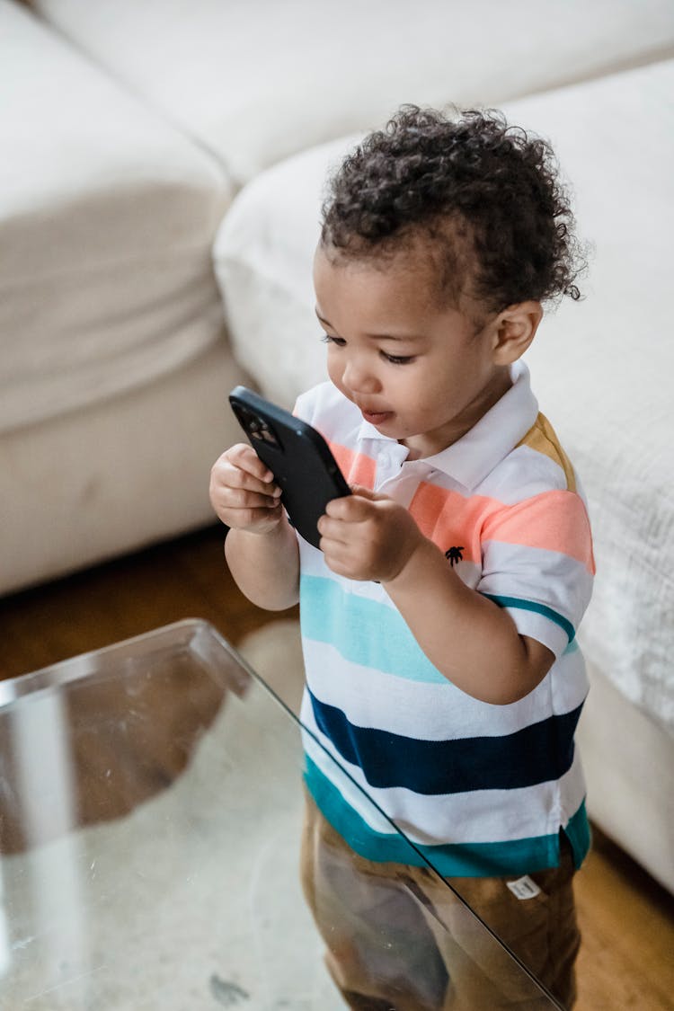 A Child Holding A Phone