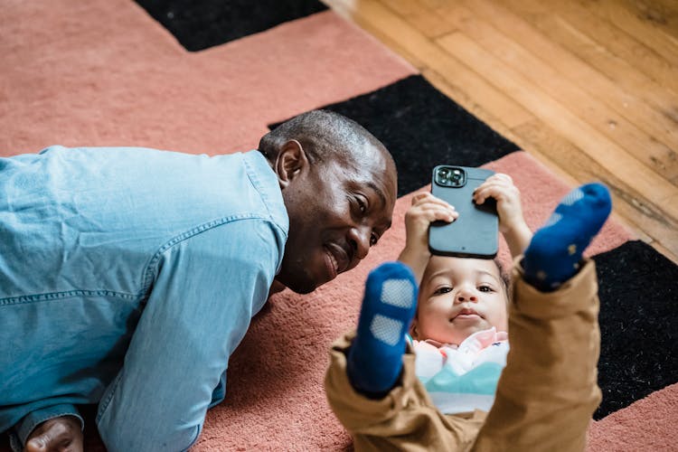 Father And Child Playing With Smartphone