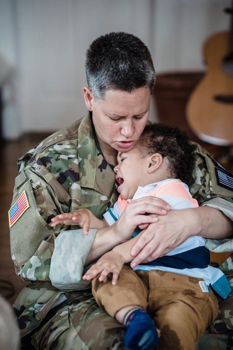 Woman In Army Uniform Holding A Boy Crying