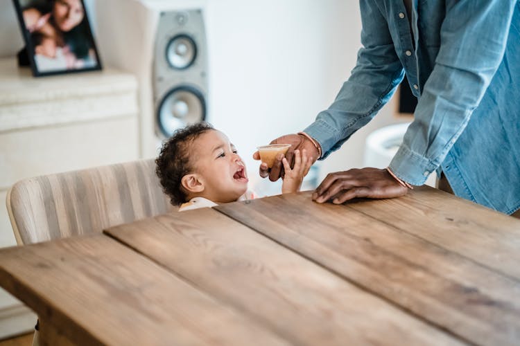 Crying Hungry Boy By A Table Getting Food