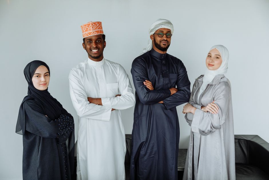 Portrait of four people in traditional clothing, standing together indoors.