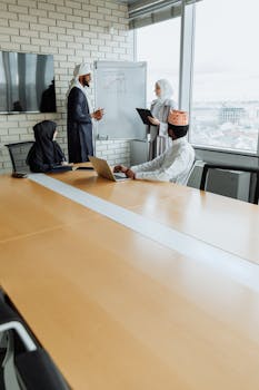 Diverse professionals brainstorming in a modern office with a whiteboard presentation.