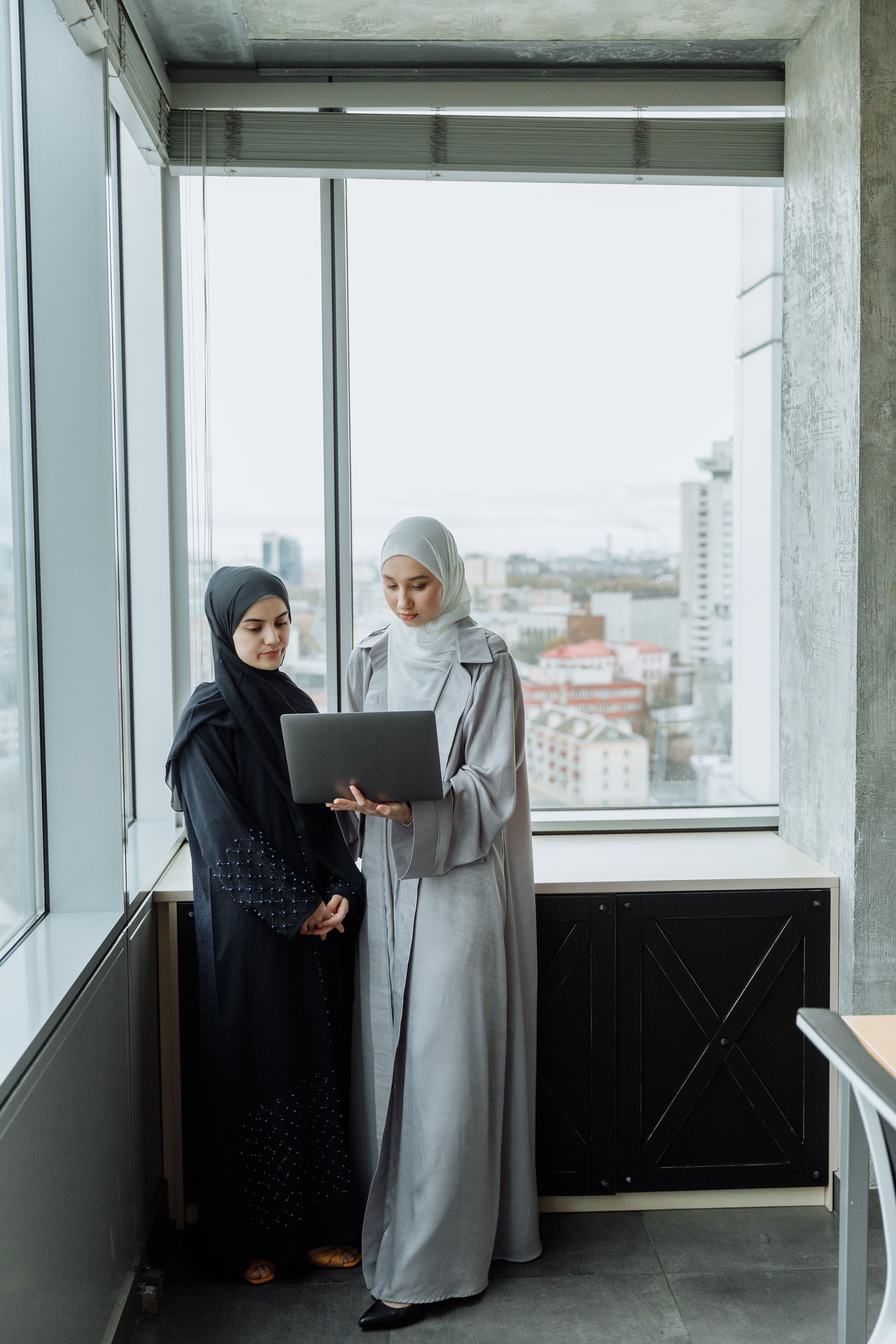 Women in Wearing Abaya and Hijab Holding a Laptop · Free Stock Photo