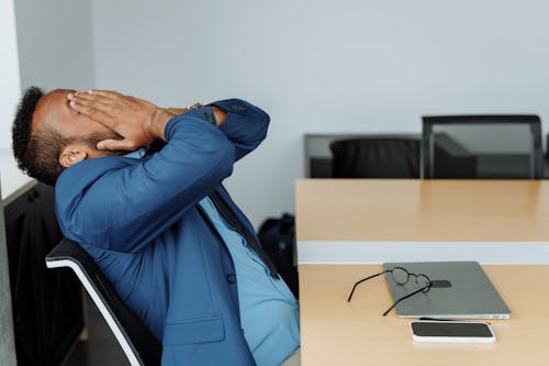 Free A Stressed Businessperson Sitting at a Desk Stock Photo