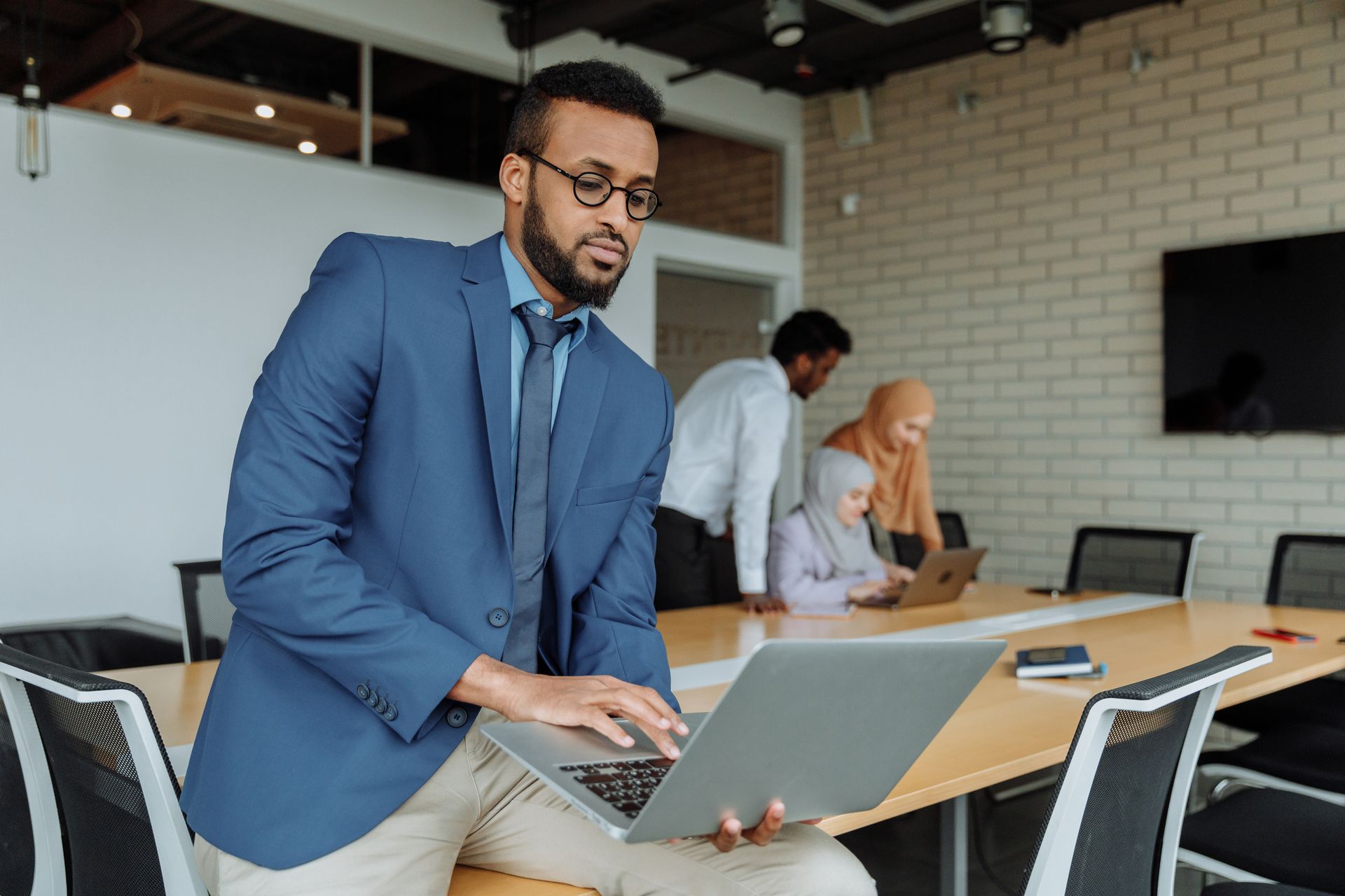 Man in Blue Suit Jacket Using a Laptop