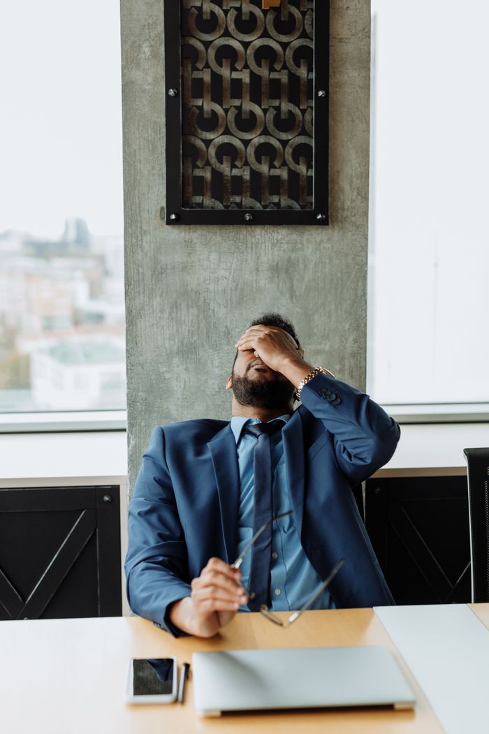 An overwhelmed person holding their head in their hands