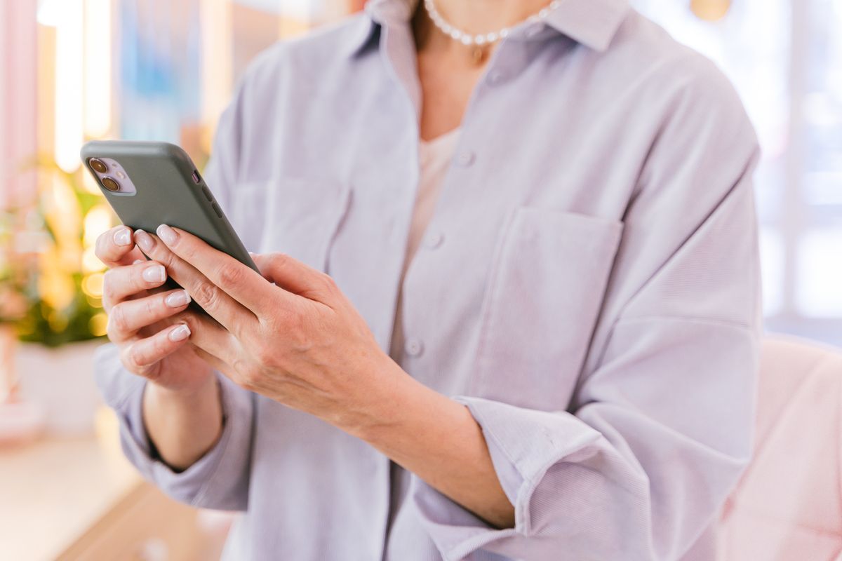 Akıllı telefon ekranına bakan ve işlem yapan bir kullanıcı