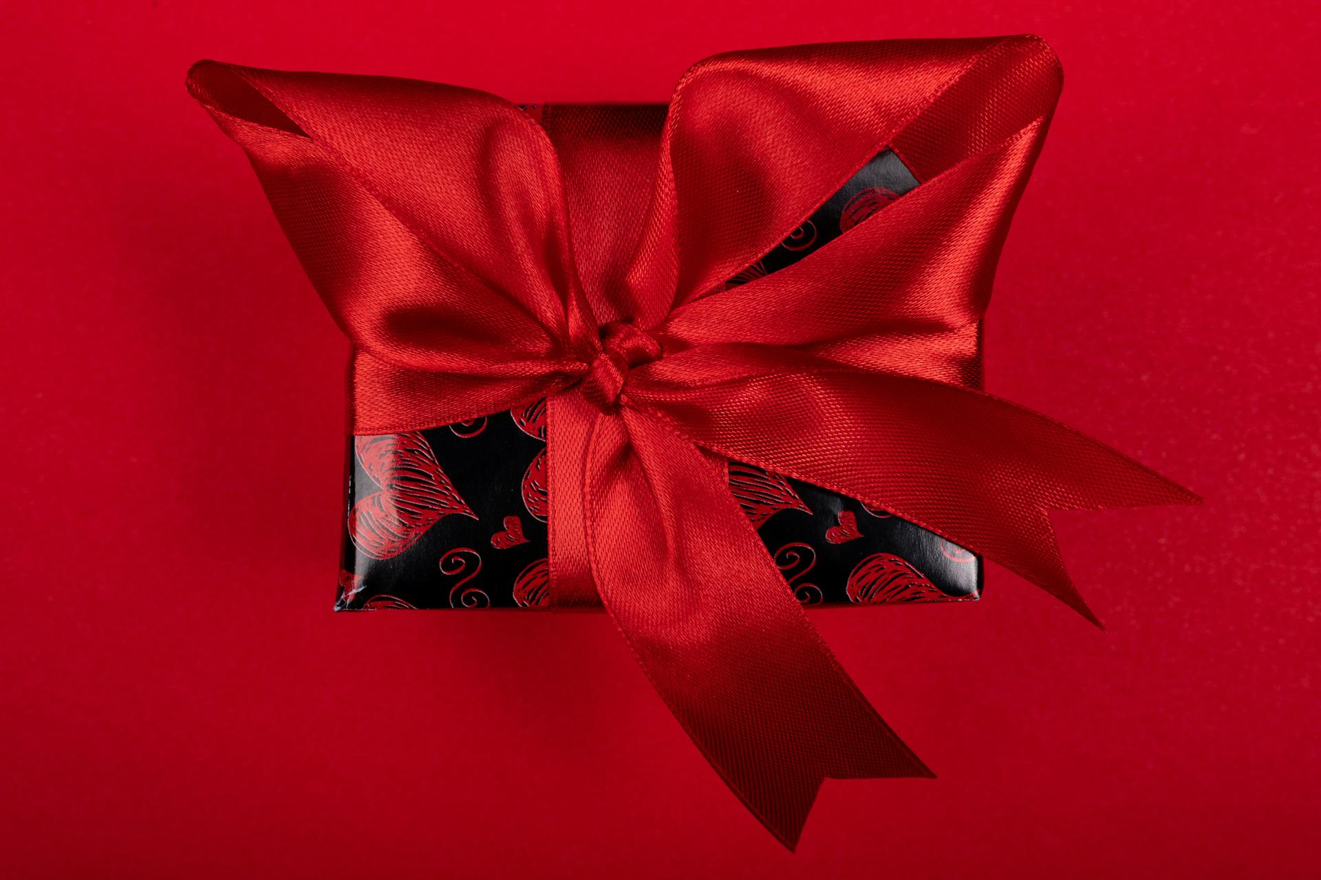 Top view of a beautifully wrapped red gift box with a satin ribbon, perfect for Valentine’s Day.