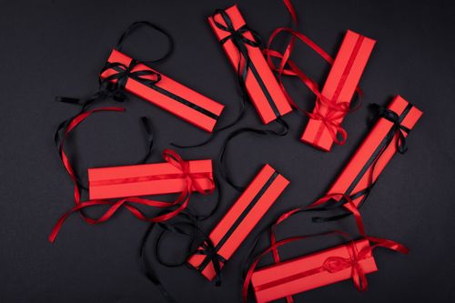 Free Top view of luxurious red gift boxes with black ribbons on a black background. Stock Photo