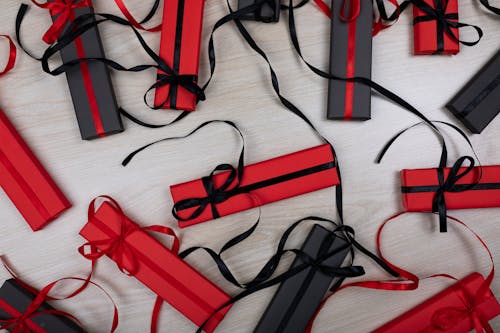 Red and Black Wrapped Gift Boxes on Wooden Surface