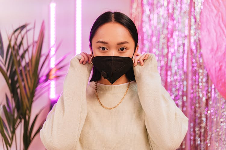 Woman In Beige Sweater Wearing Black Face Mask