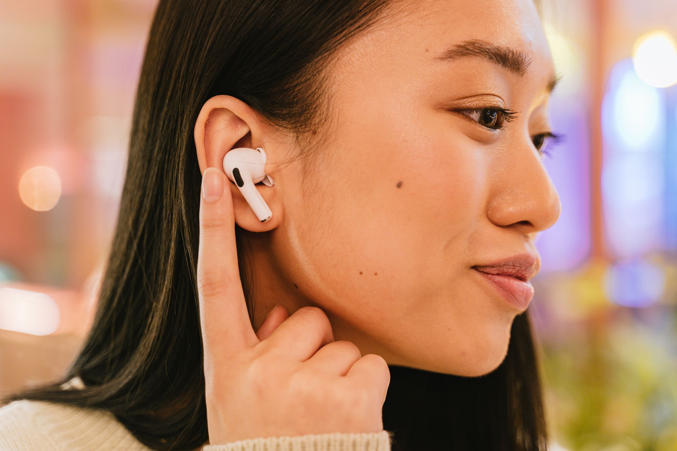 Woman wearing wireless earbuds focusing on her listening experience