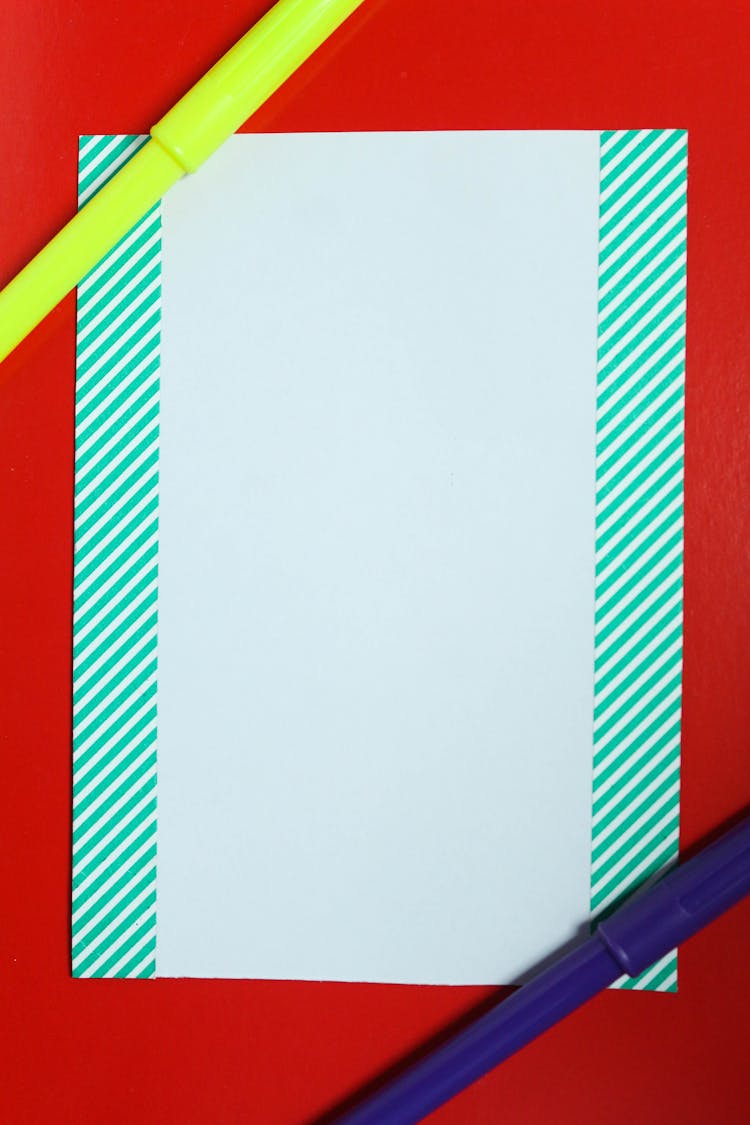 Blank Paper With Stripes On Border On Red Background