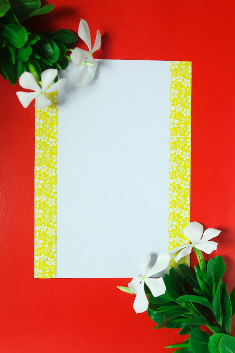 Blank Paper With Yellow Floral Border On Red Background