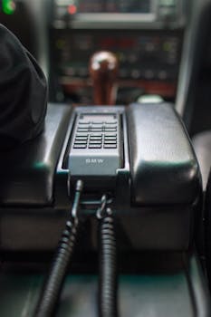 Close-up of a retro BMW car phone in the vehicle's interior, showcasing classic design.