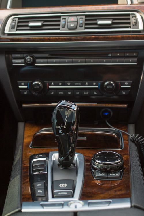 Free A close-up view of a luxury car interior featuring a stylish gear shift and dashboard control panel. Stock Photo