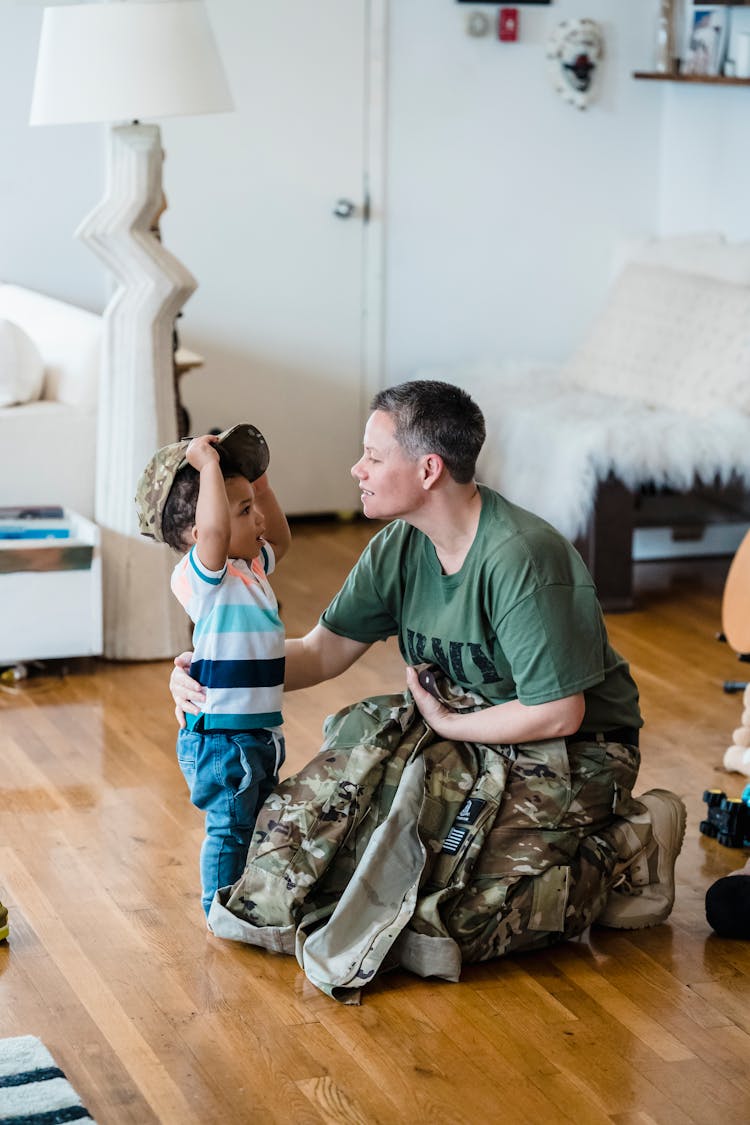 Parent Wearing Army Uniform In Front Of A Kid