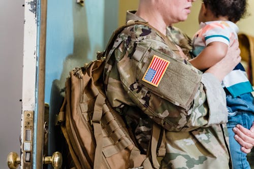 Woman in a Military Uniform Holding her Toddler