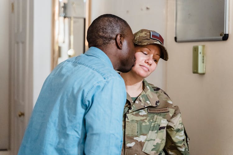 Man Kissing Military Woman On Cheek