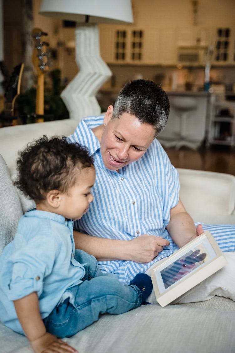 Woman And Child Looking At Photo In Frame