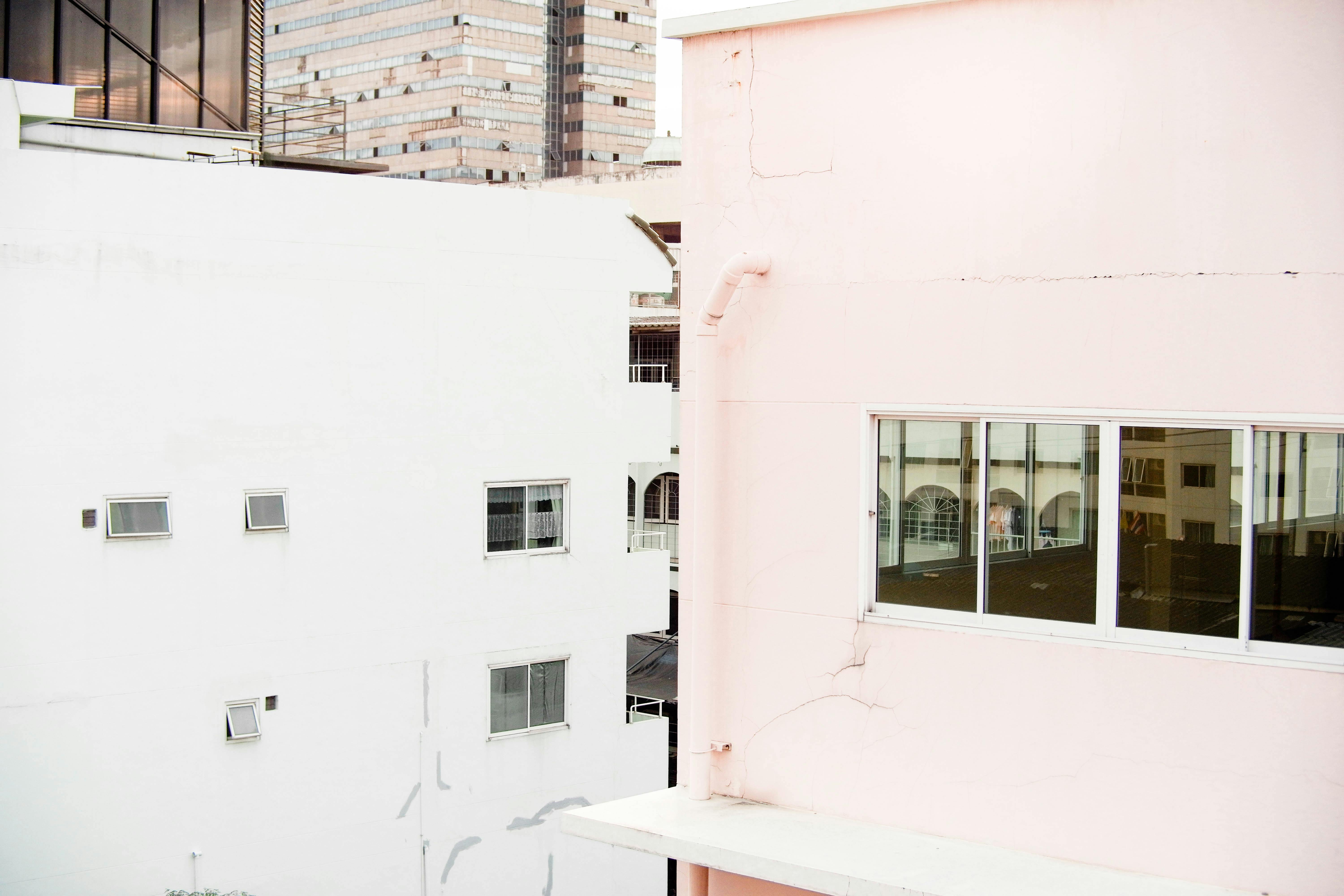 Captivating view of urban buildings featuring modern pastel facades and large windows under daylight.