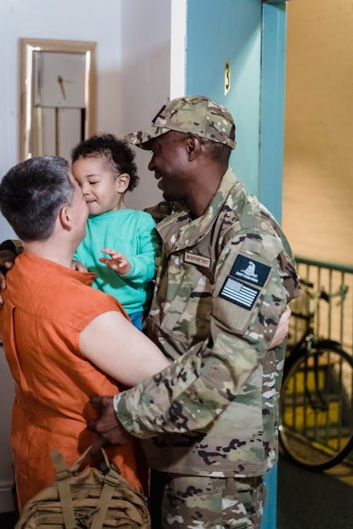 Man in a Military Uniform Embracing his Wife and Son