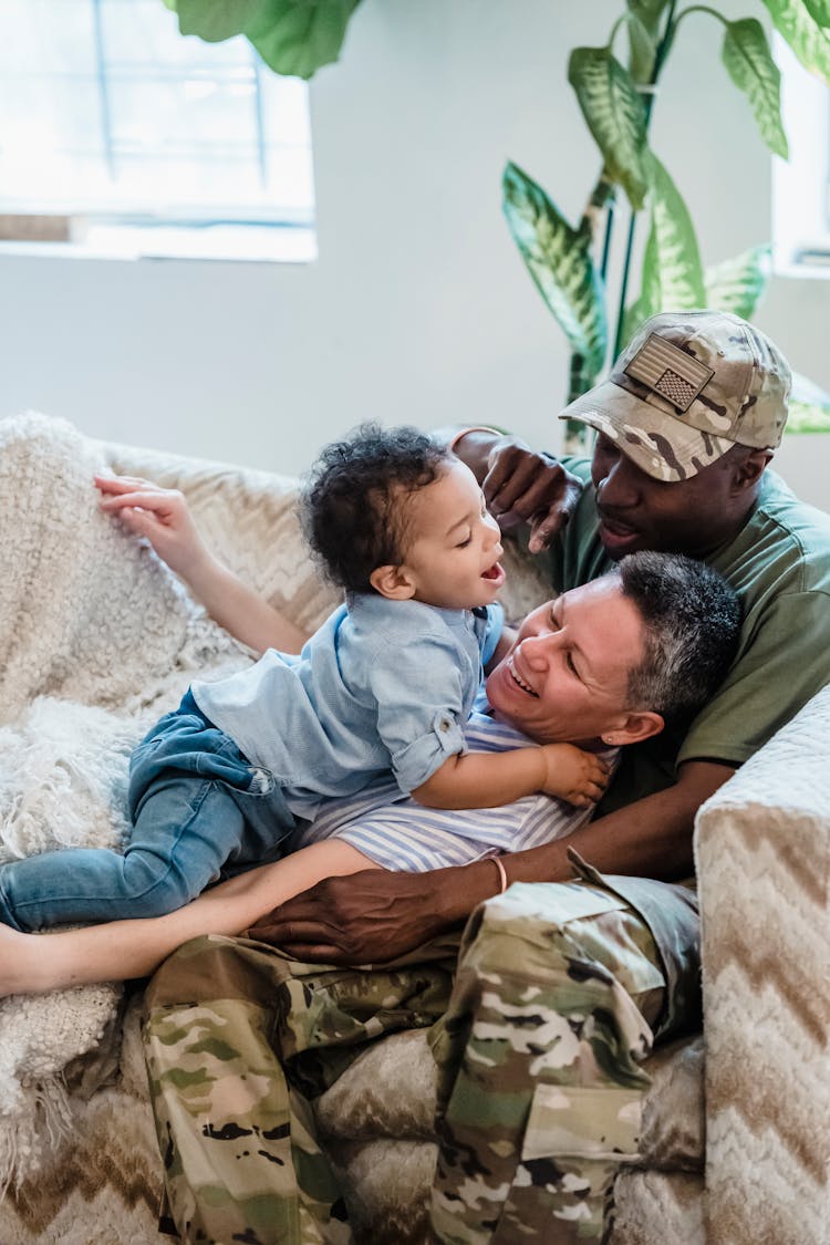 Happy Family With Soldier Parent Playing At Home