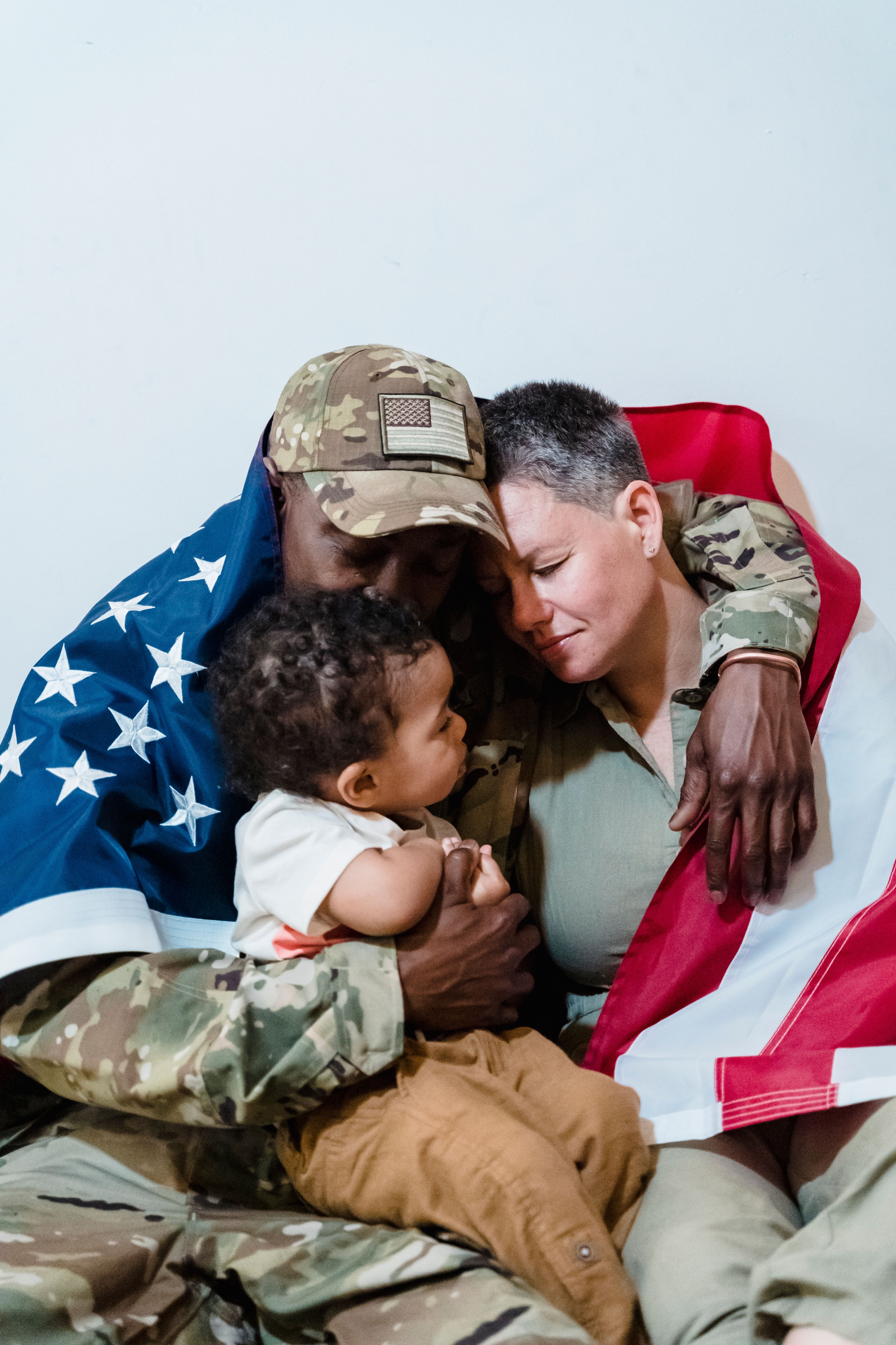 Military family with their child wrapped in an American flag