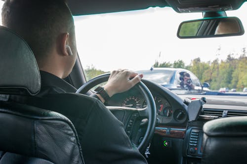 A Man in Black Long Sleeve Shirt Driving a Car