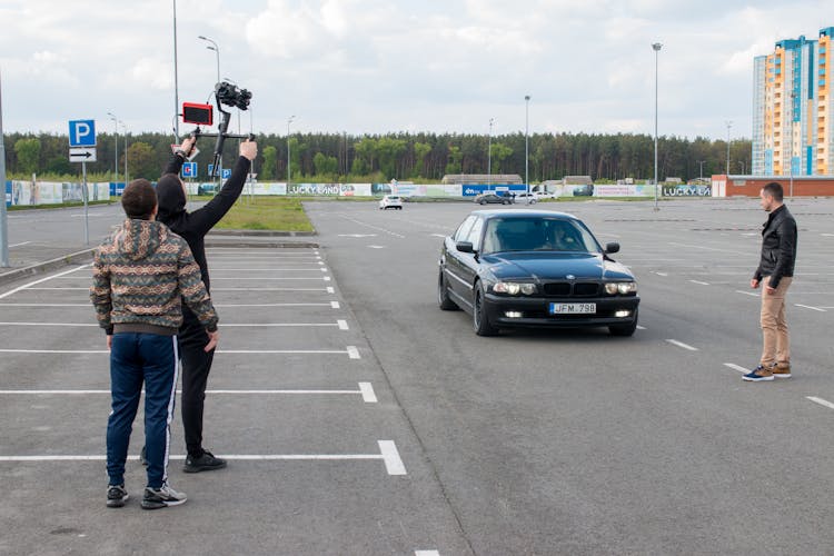 Camera Man Filming A Driver Of Car In A Parking Lot