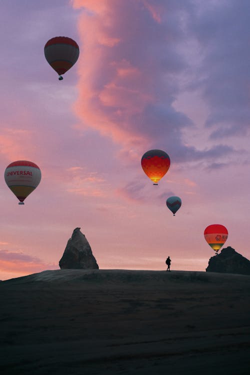 Hot air balloons flying over rocky terrain