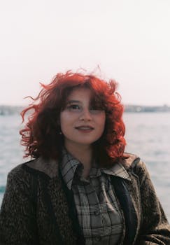 Beautiful woman with red hair smiling by the Bosphorus in Istanbul, Turkey.