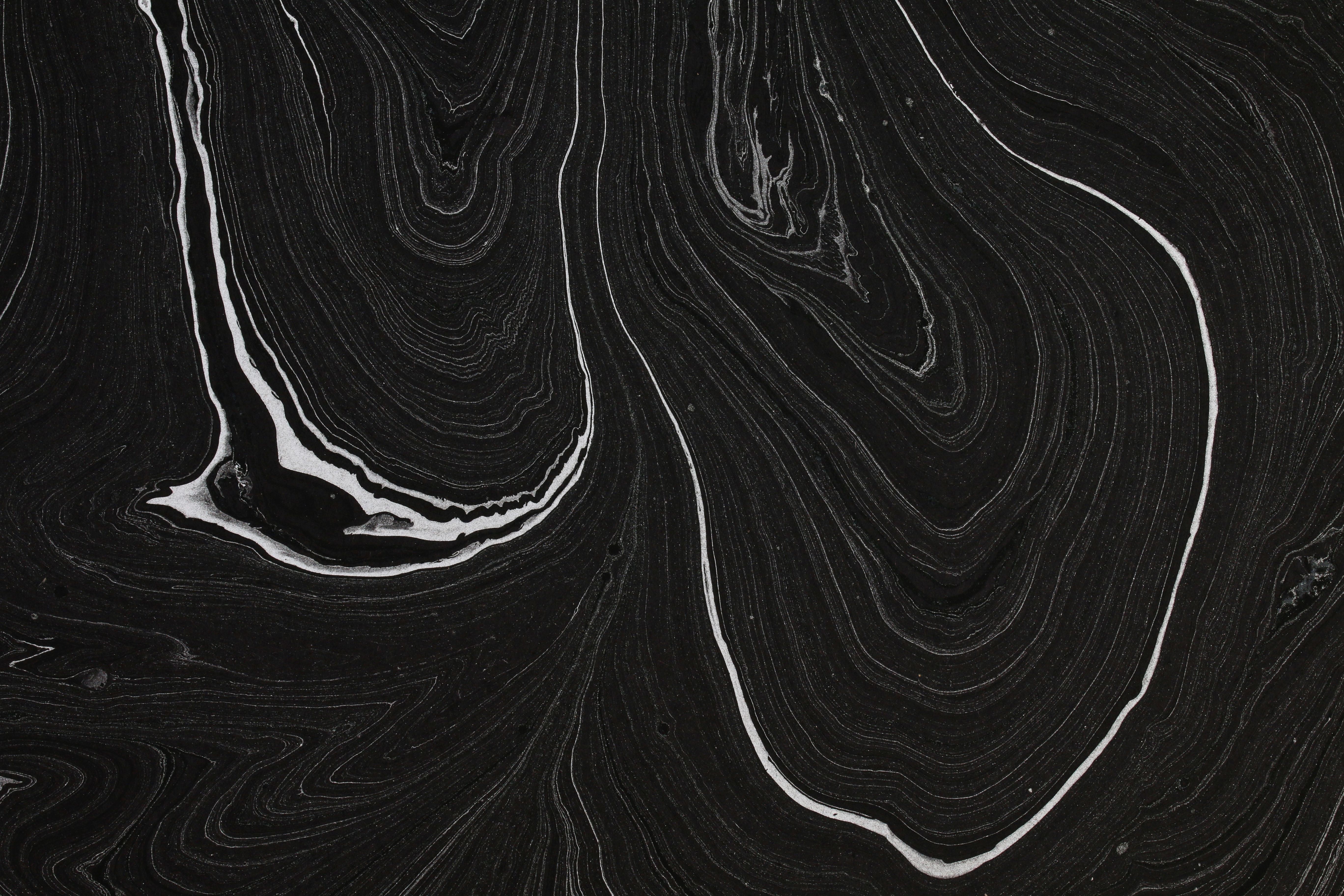Black and white abstract texture resembling marble with swirling patterns.
