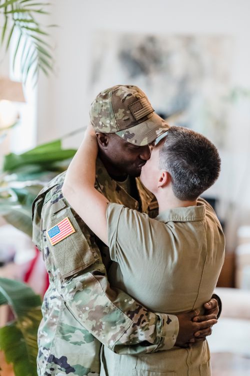 Free A loving embrace between a couple, one in military uniform, captured indoors. Stock Photo