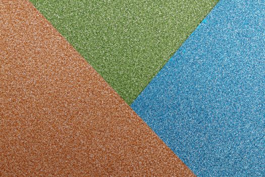 Vibrant abstract image with glittery texture in green, blue, and brown hues.