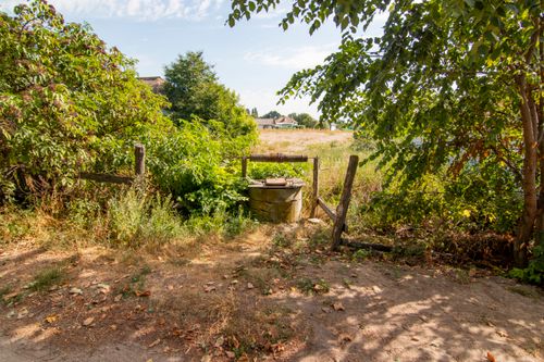 Free A scenic view of a rustic well surrounded by lush greenery in the countryside. Stock Photo