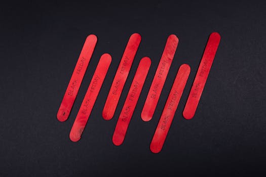 Red popsicle sticks displaying Black Friday text on a black background. Perfect for sales promotions.