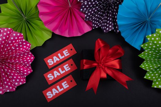 Colorful origami and gift box with red ribbon highlight a sale theme.